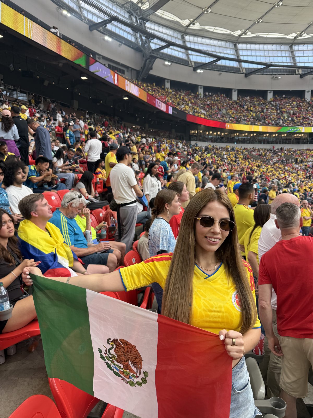 Isabella in a Mexico jersey holding the flag at a stadium