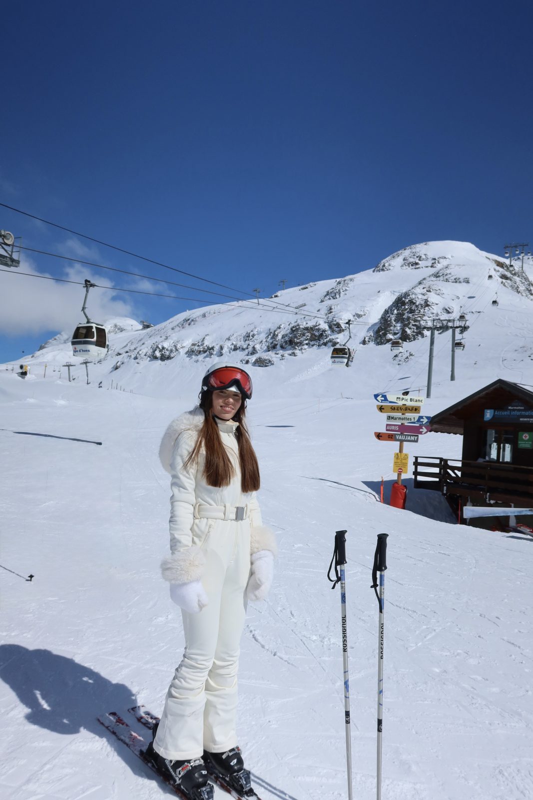 Isabella in a white ski suit in the snow