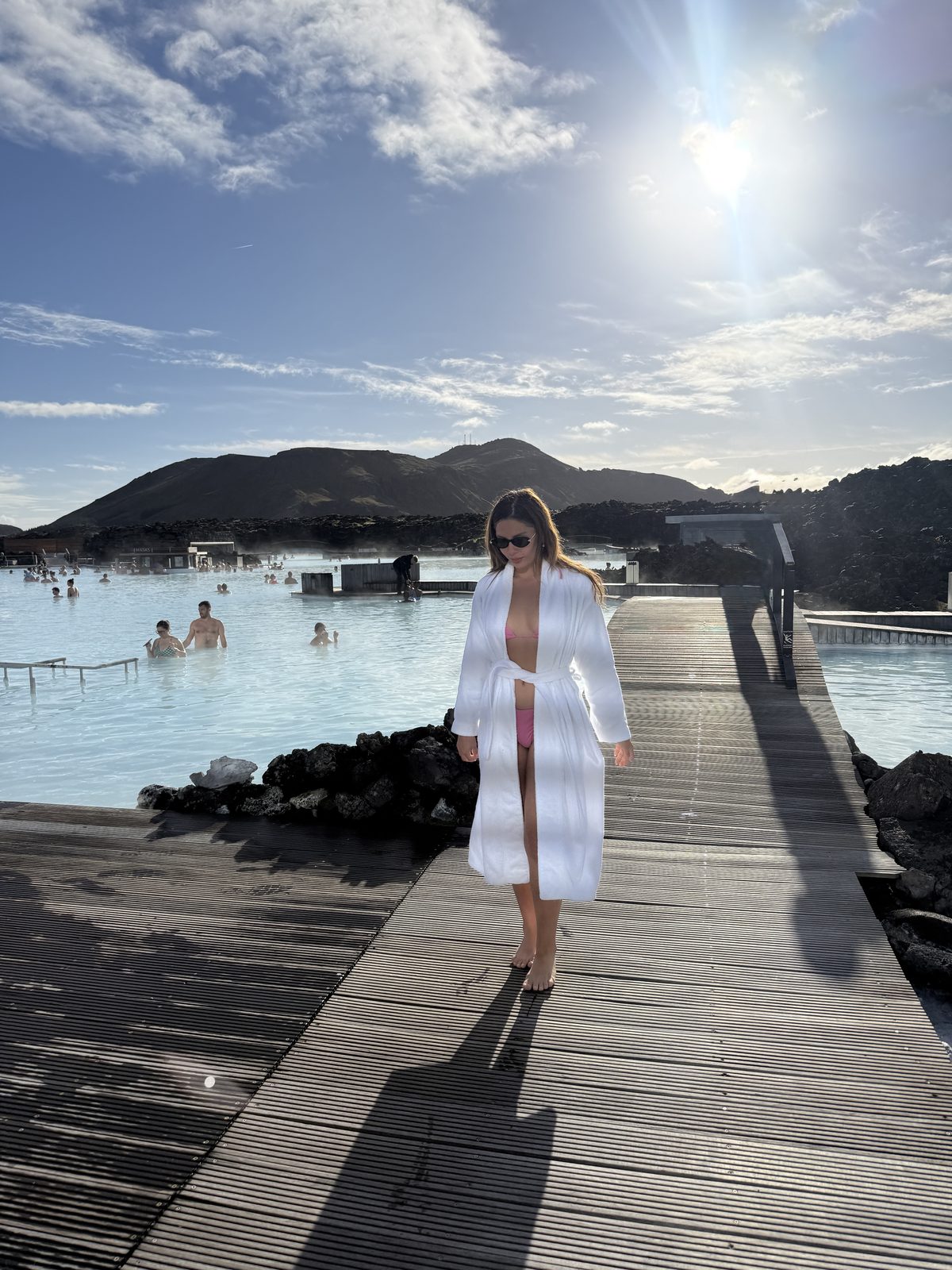 Isabella on a wooden boardwalk by turquoise hot springs